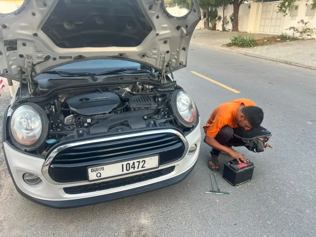 a mobile tyre fixre worker fixing a a car tyre on the road